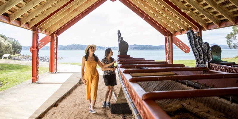 Two women admiring a waka at the Treaty of Waitangi grounds.