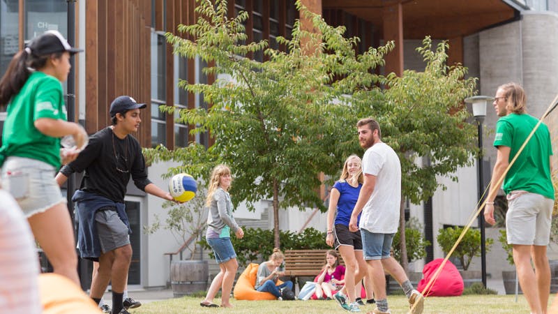 students outside university during orientation week playing volleyball