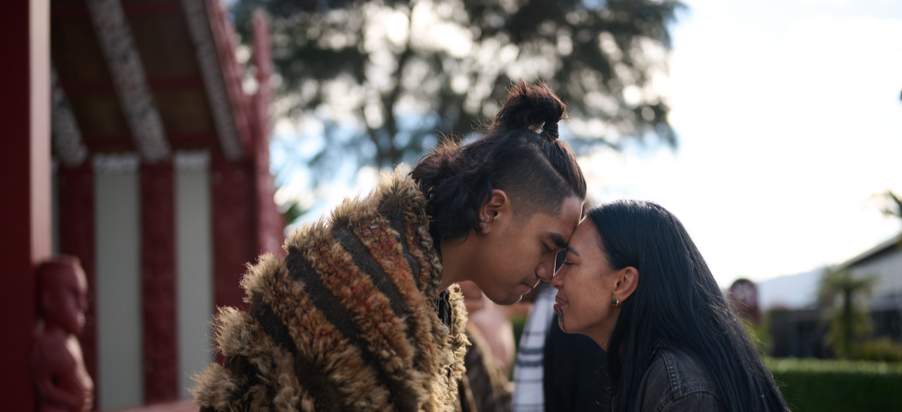 Two people doing a hongi in front of ROTOWHIO MARAE.