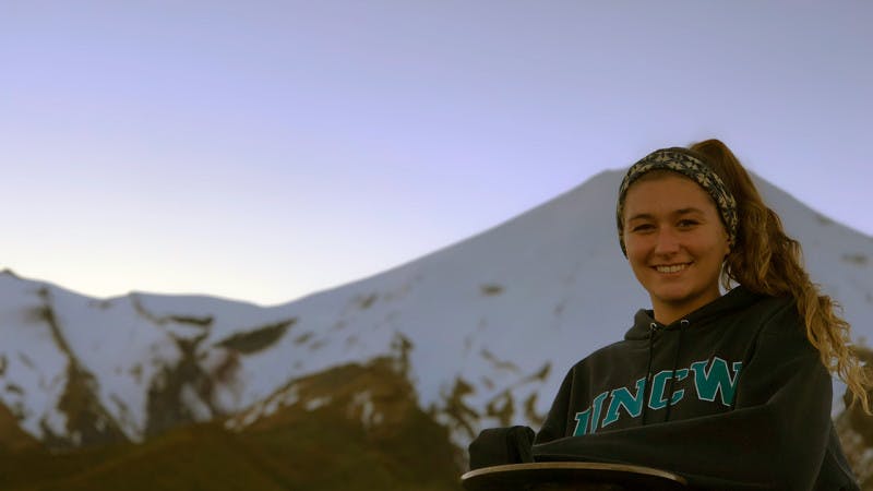 Blog author Sophie standing in front of a snow covered mountain in New Zealand.