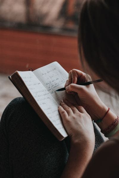 A woman writing down goals in her diary.