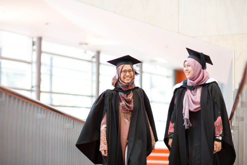 Two women wearing a head scarf and graduating from university in New Zealand.